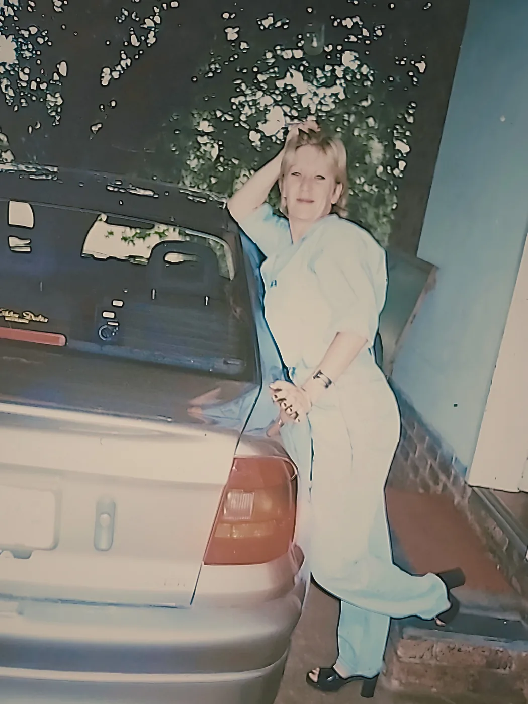 Julie leaning against a car back in the 90s