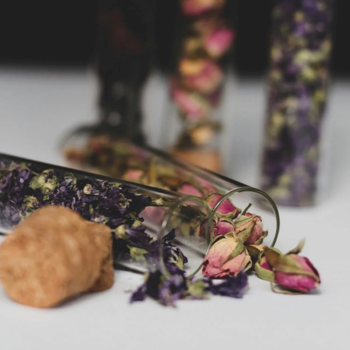 Glass vials filled with dried rose petals and botanicals