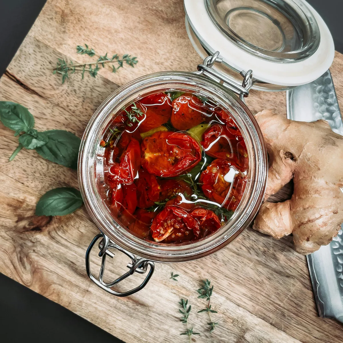 A jar of slow-roasted tomatoes preserved in oil with thyme and ginger